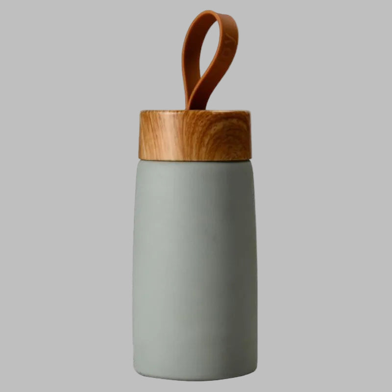 Gray mug with a wooden lid and handle on a white background